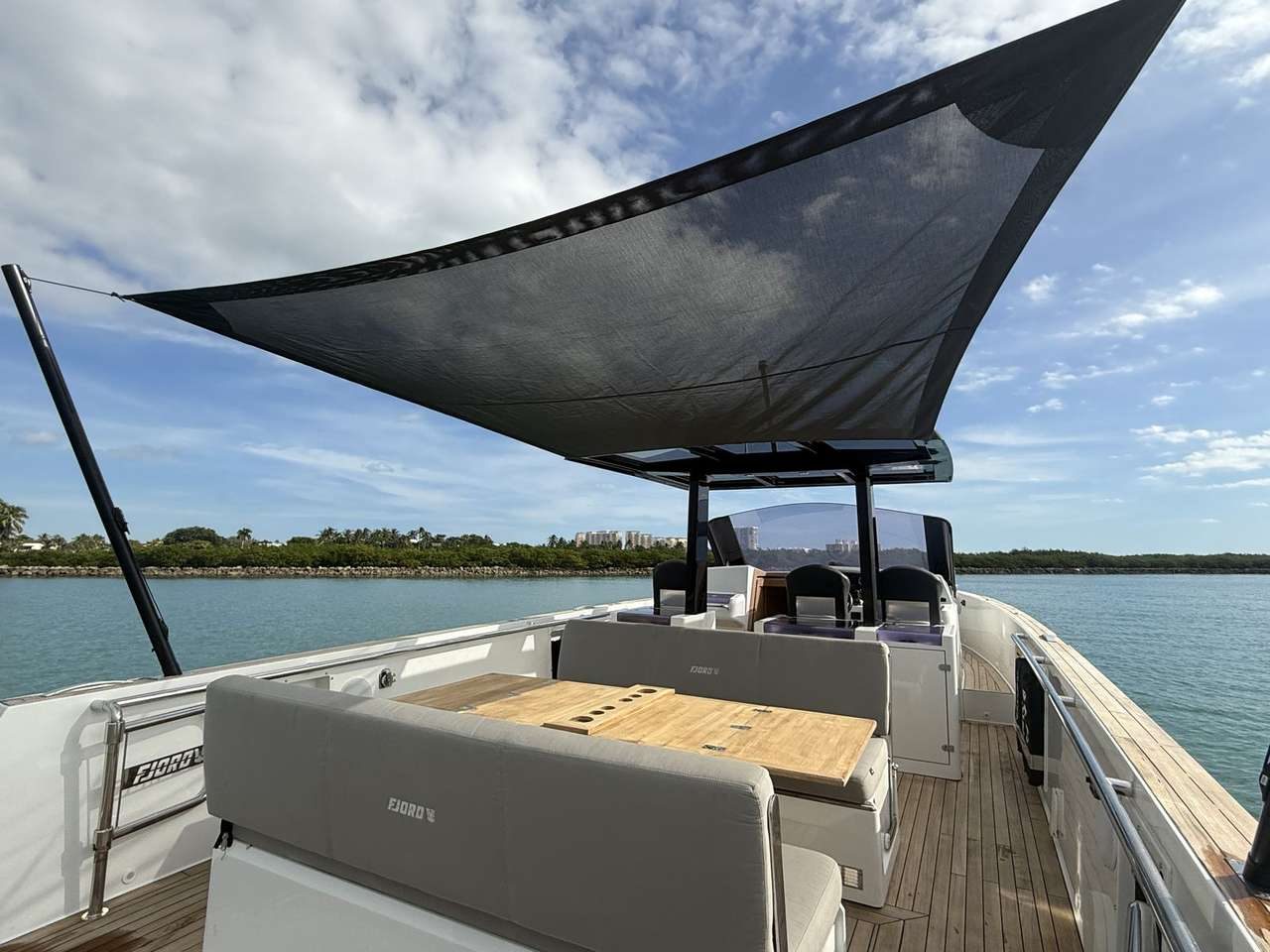 Aft entertaining area with teak table and shade canopy